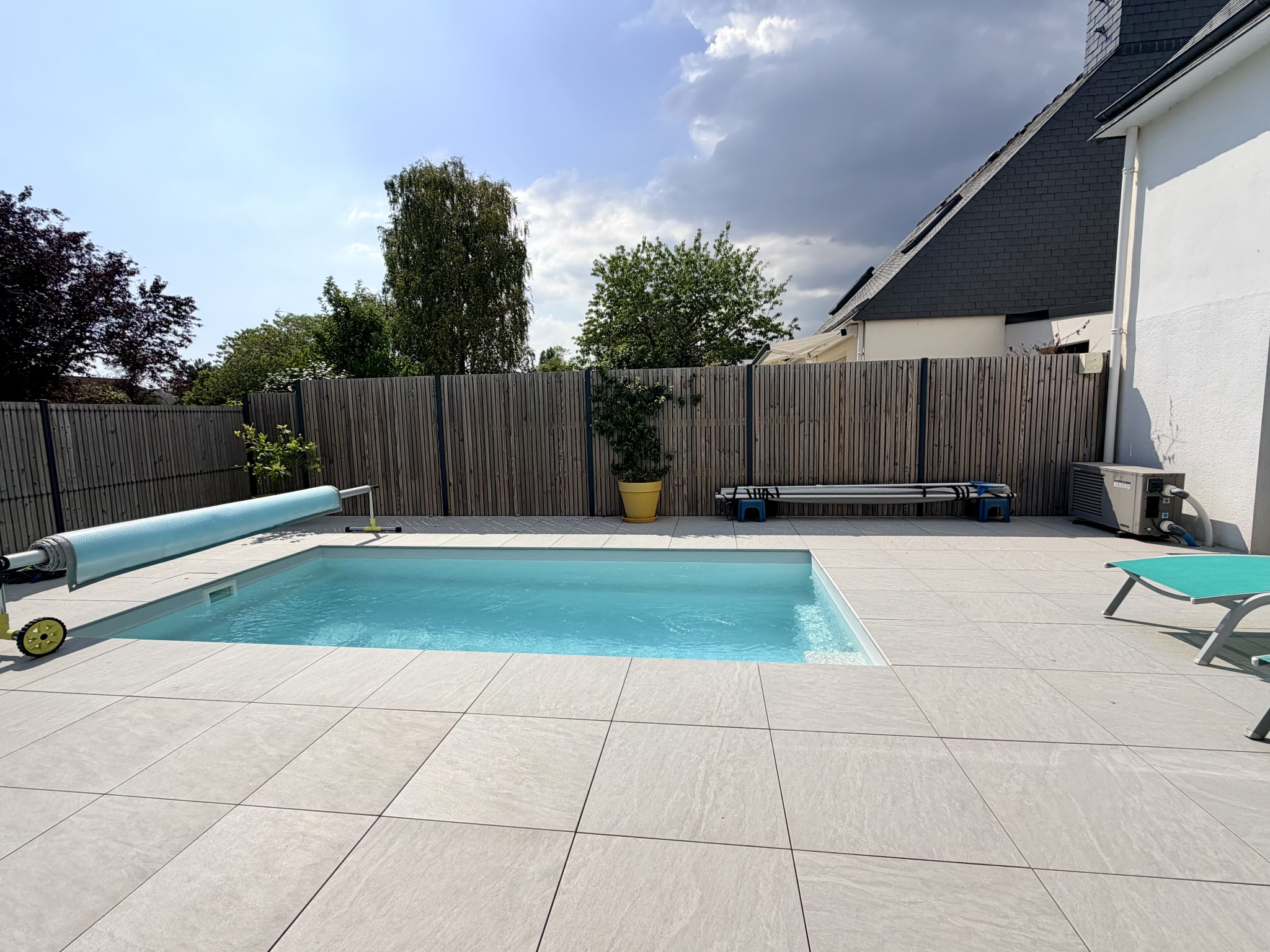 Piscine et terrasse en carrelage d'une maison contemporaine à Vannes.