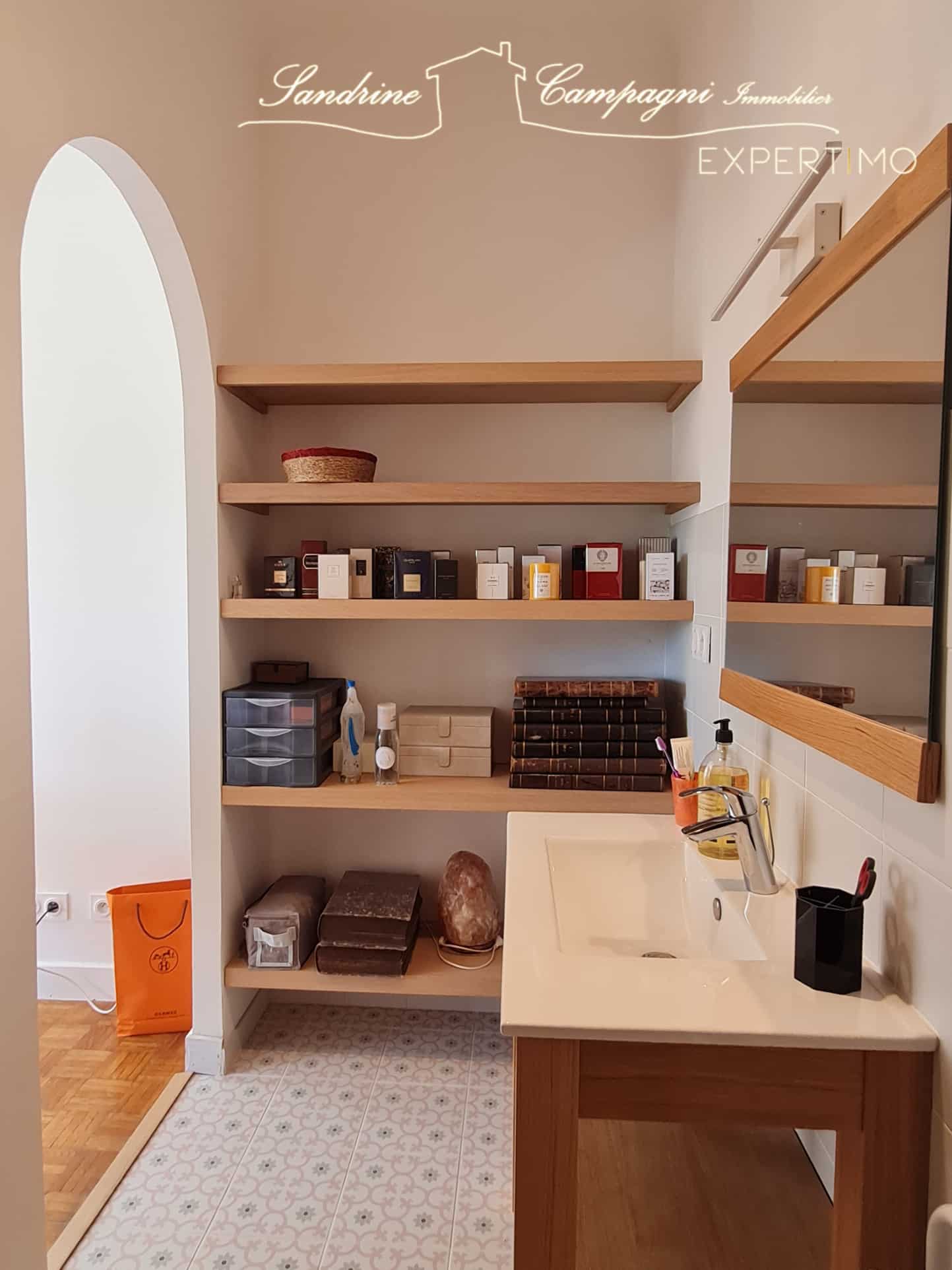Intérieur d'une salle de bain rénovée avec étagères et lavabo.