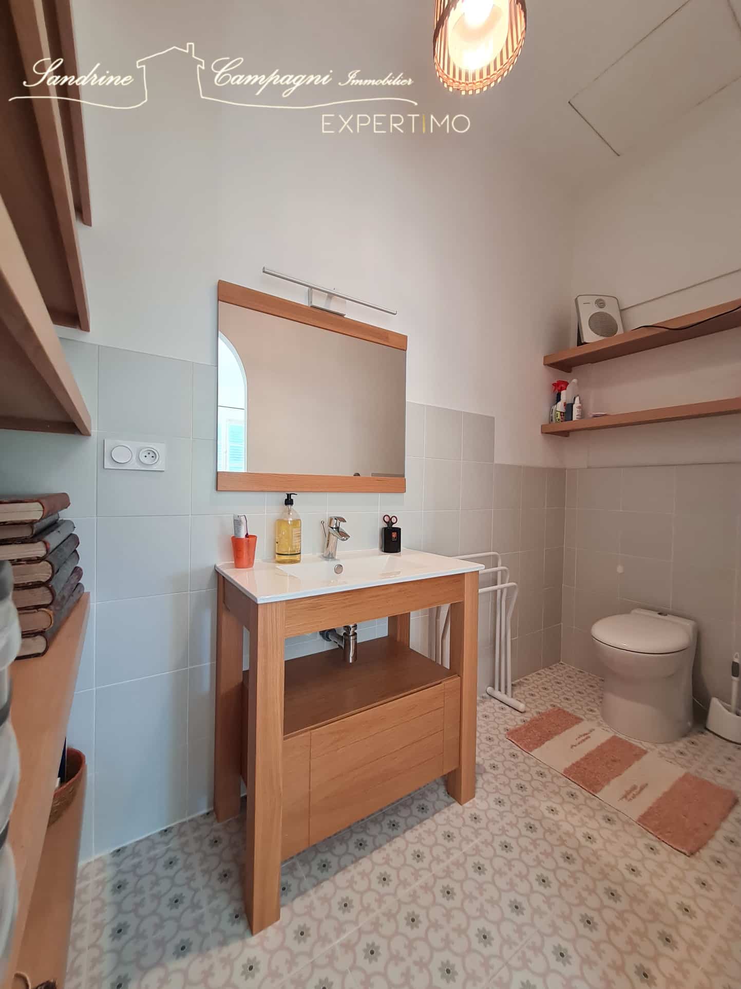 Salle de bain moderne avec meuble en bois et carrelage décoratif.