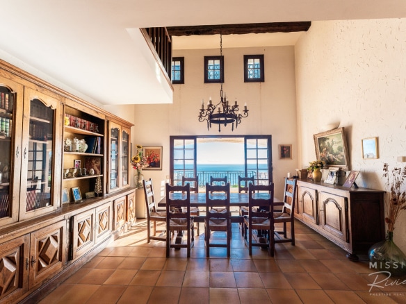 Interior of a Provençal villa with sea view, dining room and wooden library.