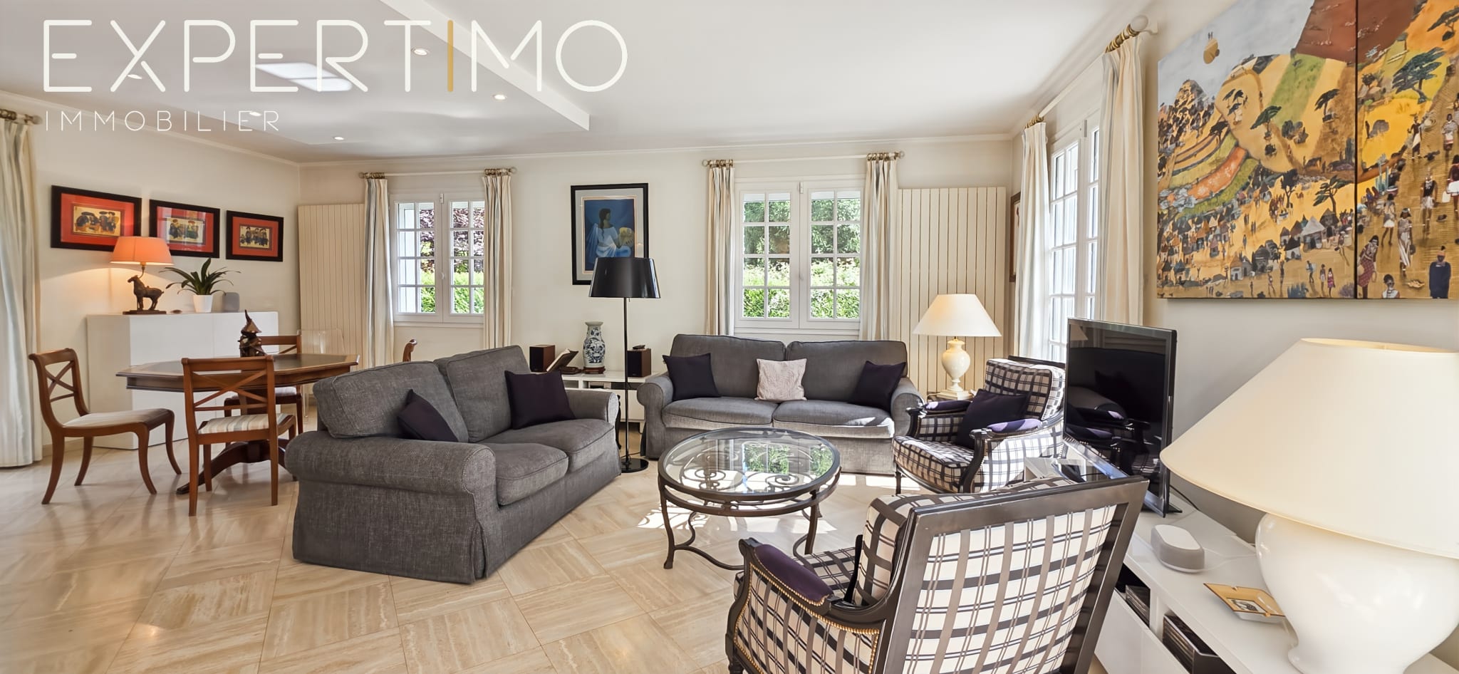 Interior of a bright living room with elegant furniture and windows overlooking the garden.