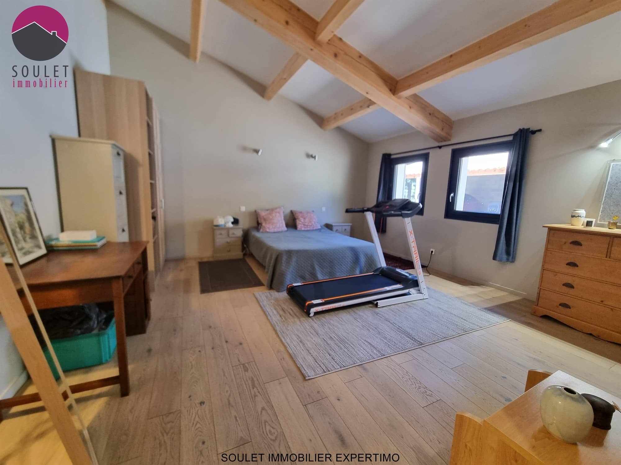 Chambre d'une propriété à Bédoin avec lit, tapis et mobilier en bois.