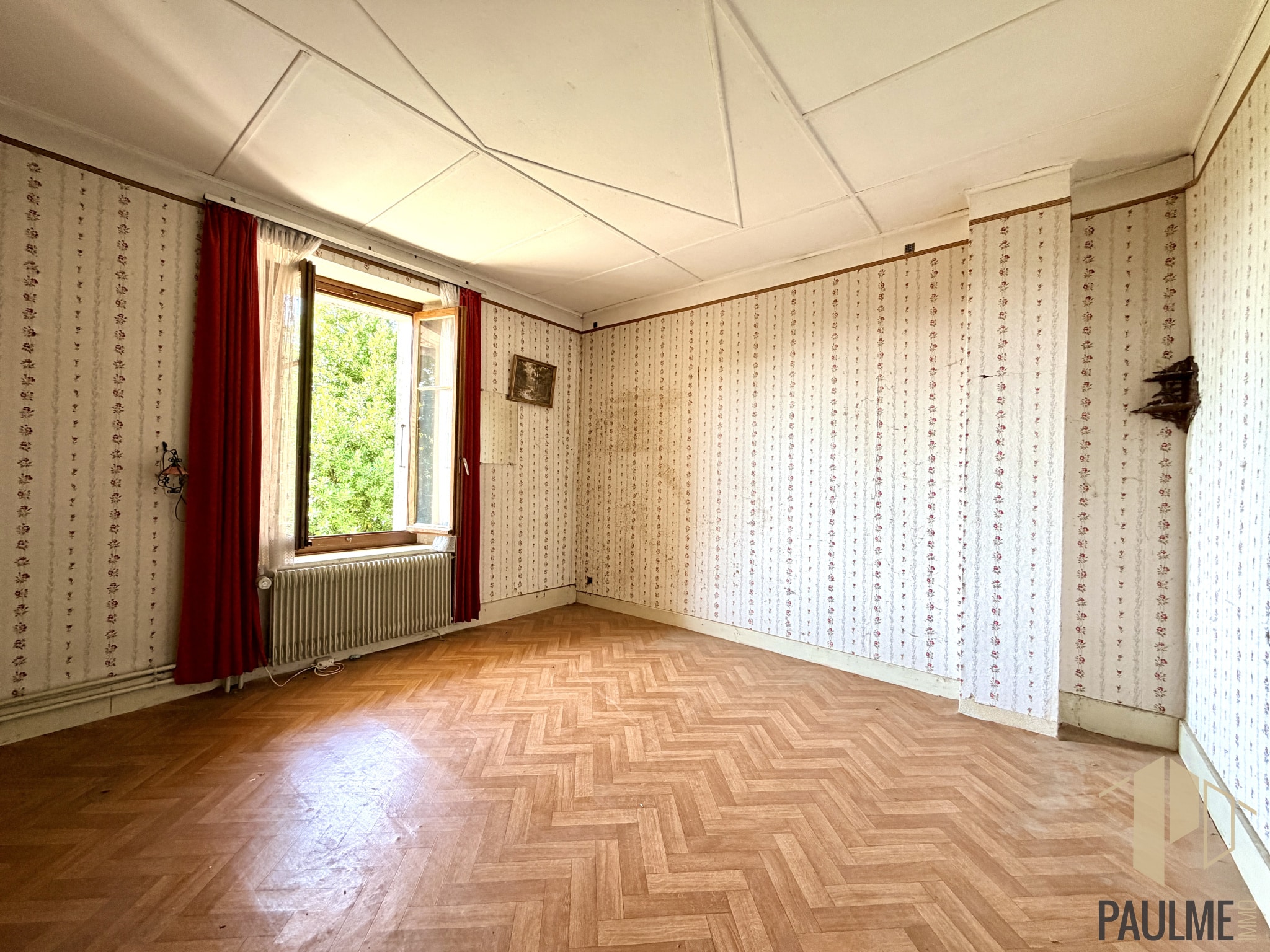 Intérieur d'une grange à rénover à Ornex, avec parquet et murs à motifs.