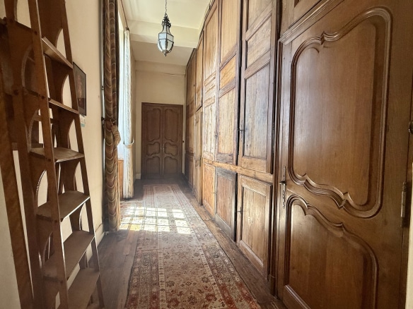 Intérieur d'un château avec un couloir en bois et des portes anciennes