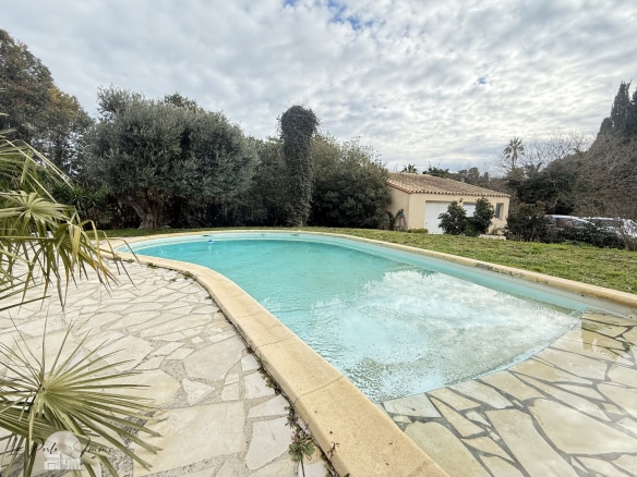 Piscine d'une villa avec jardin, entourée d'arbres, à Perpignan.