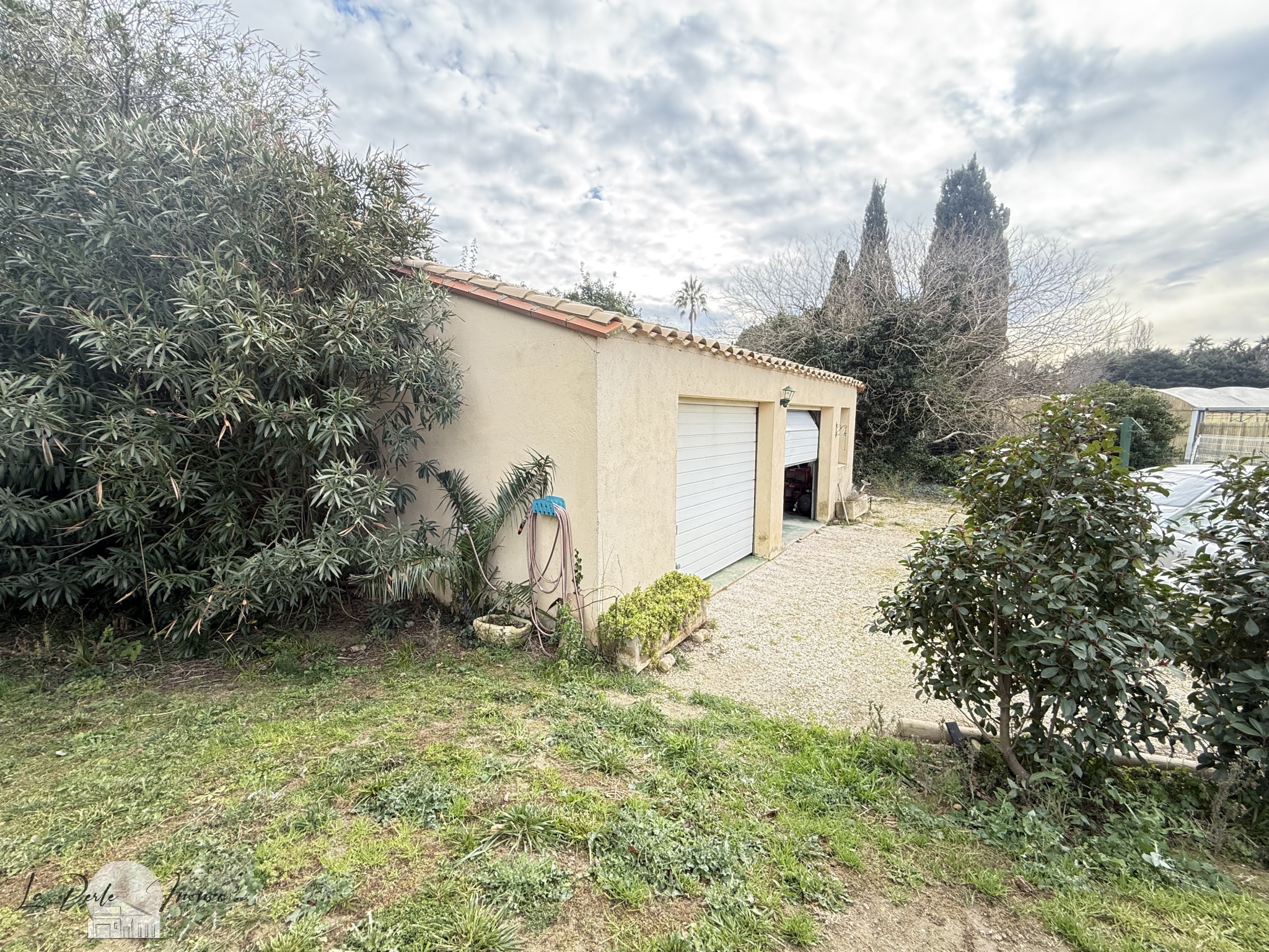 Vue extérieure d'une villa avec garage et jardin à Perpignan.