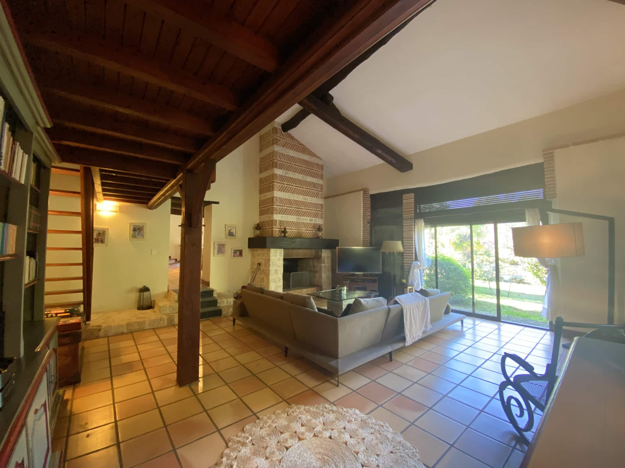 Interior of a country house with a spacious and bright living room, windows overlooking the garden.