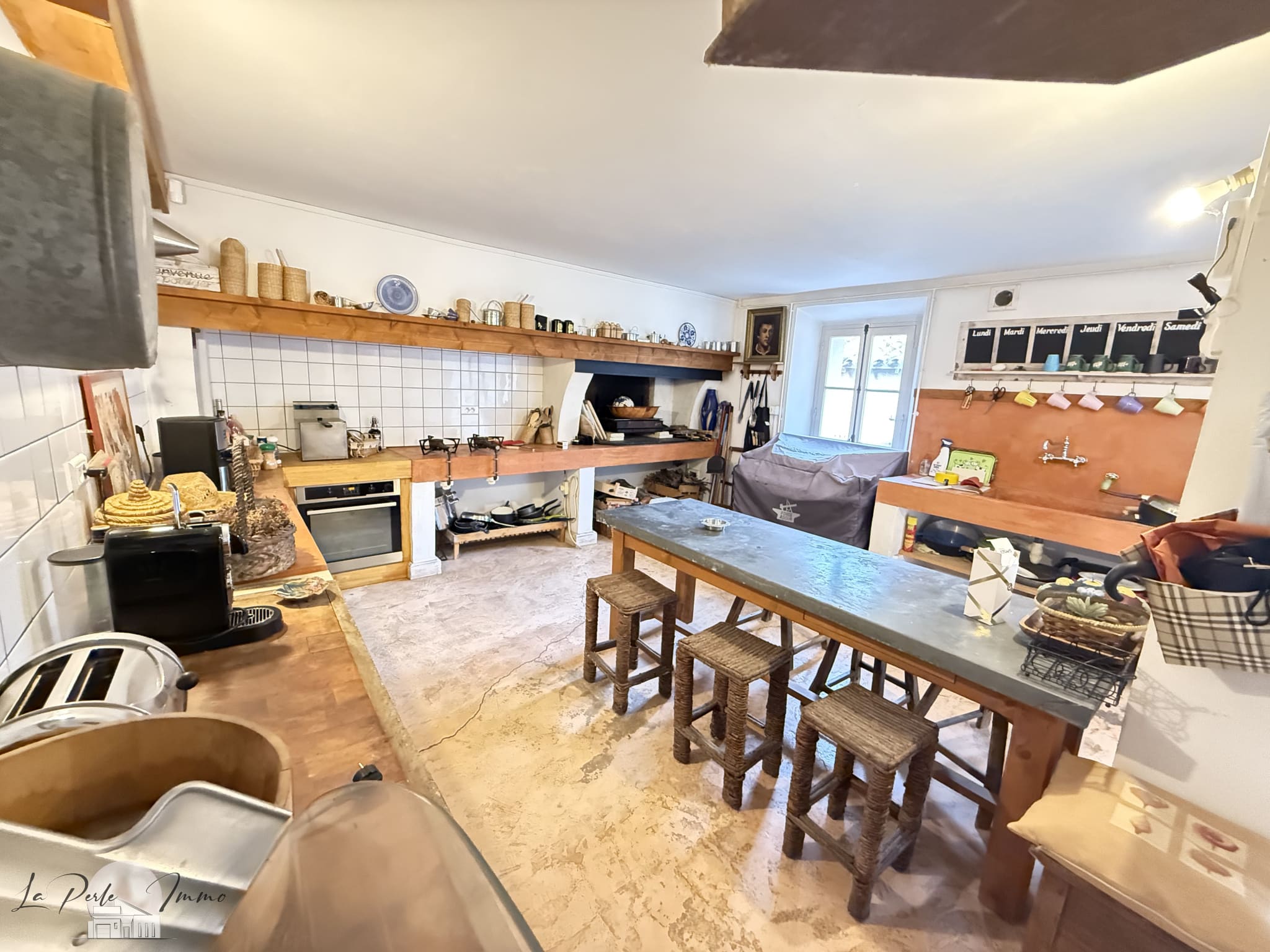 Cuisine d’une maison de maître à Villeneuve-les-Corbières Cuisine spacieuse et rénovée d'une maison de maître avec îlot central et équipements modernes.
