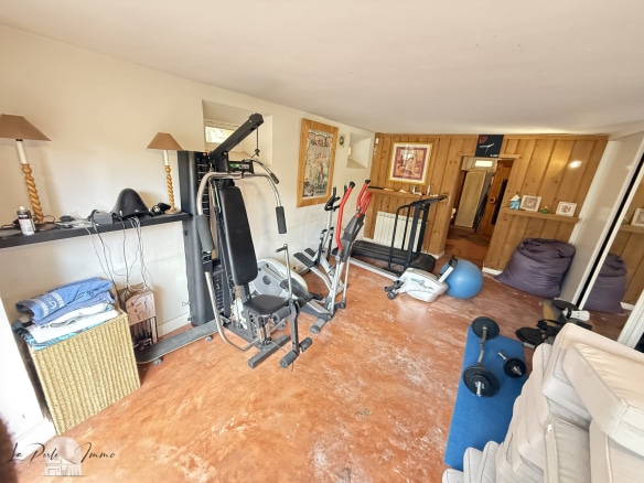 Salle de sport équipée avec appareils de fitness dans une maison de maître.