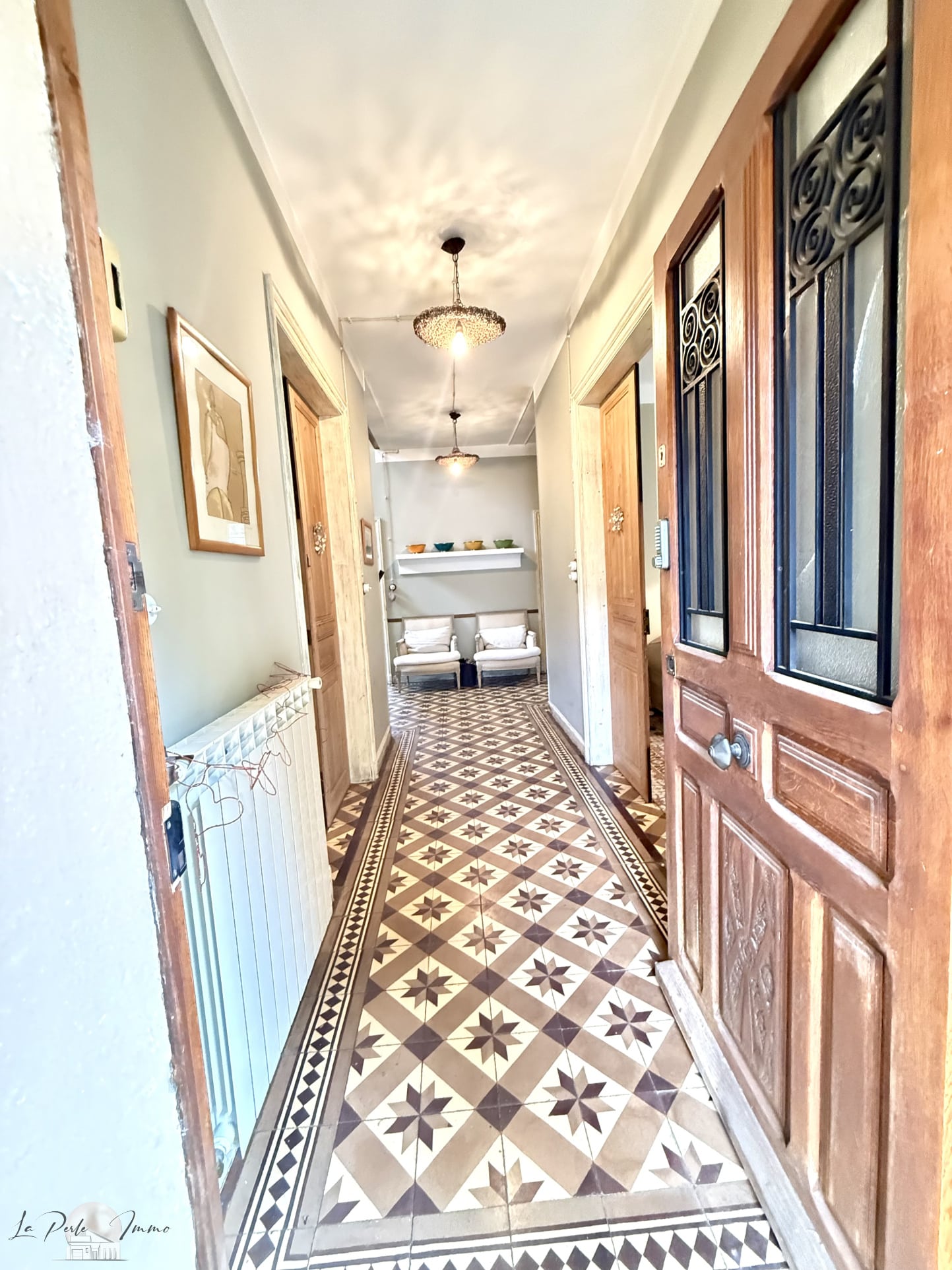 Couloir d’une maison de maître Intérieur d'une maison de maître avec un couloir décoré de carrelage ancien et des portes en bois.