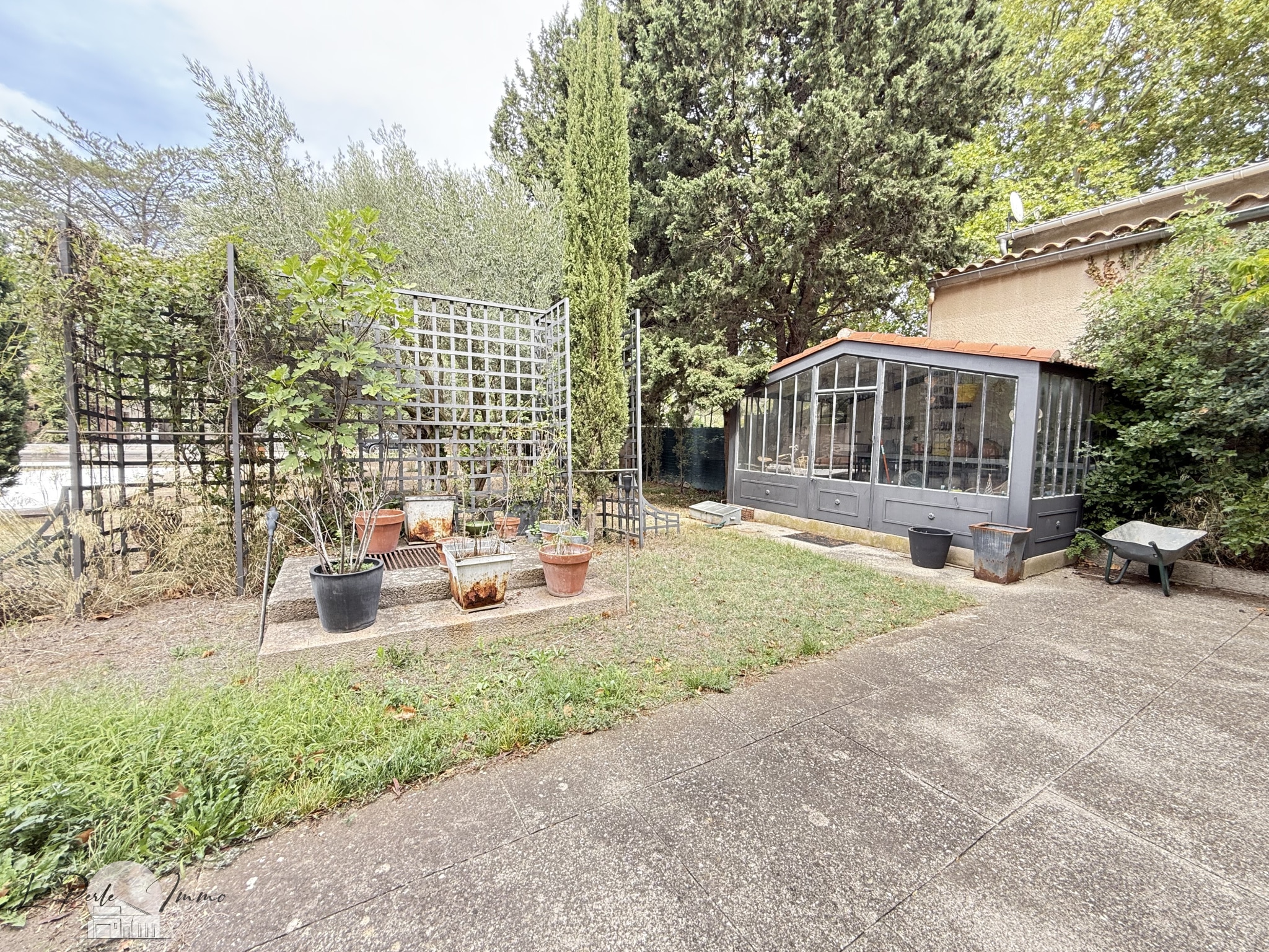Jardin de Maison de Maître à Villeneuve-les-Corbières Jardin d'une maison de maître avec véranda et espace vert.