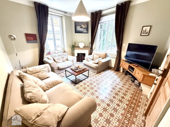 Intérieur d'une maison de maître avec salon lumineux et mobilier moderne.