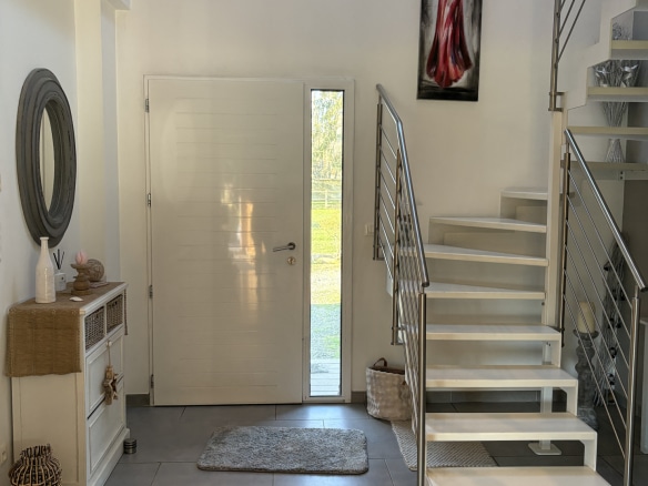 Intérieur d'une maison contemporaine avec hall d'entrée et escalier moderne.