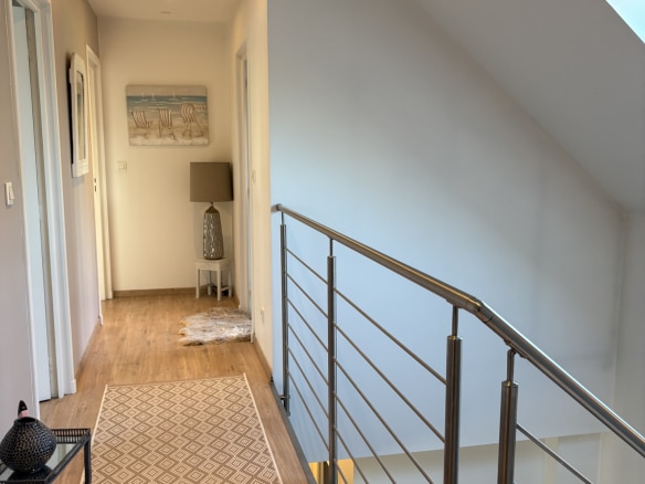 Intérieur d'une maison contemporaine avec un couloir lumineux et des finitions modernes.