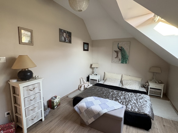 Chambre spacieuse avec lit, meubles en bois et éclairage naturel, dans une maison contemporaine à Pacy-sur-Eure.