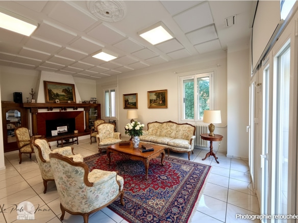 Intérieur d'une maison de maître à Perpignan avec salon lumineux et mobilier ancien.