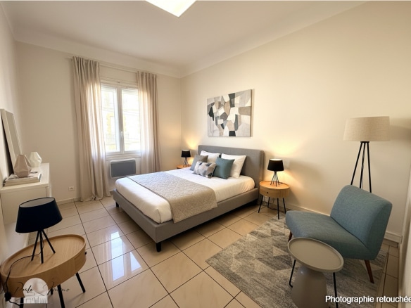 Chambre d'une maison de maître à Perpignan, avec lit double, fauteuil et décoration moderne.