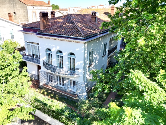 Maison de maître à Perpignan avec façade caractéristique et jardin verdoyant.