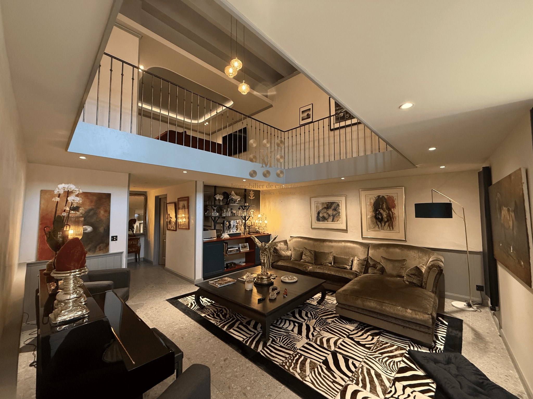 Intérieur d'une maison de maître avec salon spacieux et escalier en pierre, décor moderne et élégant.