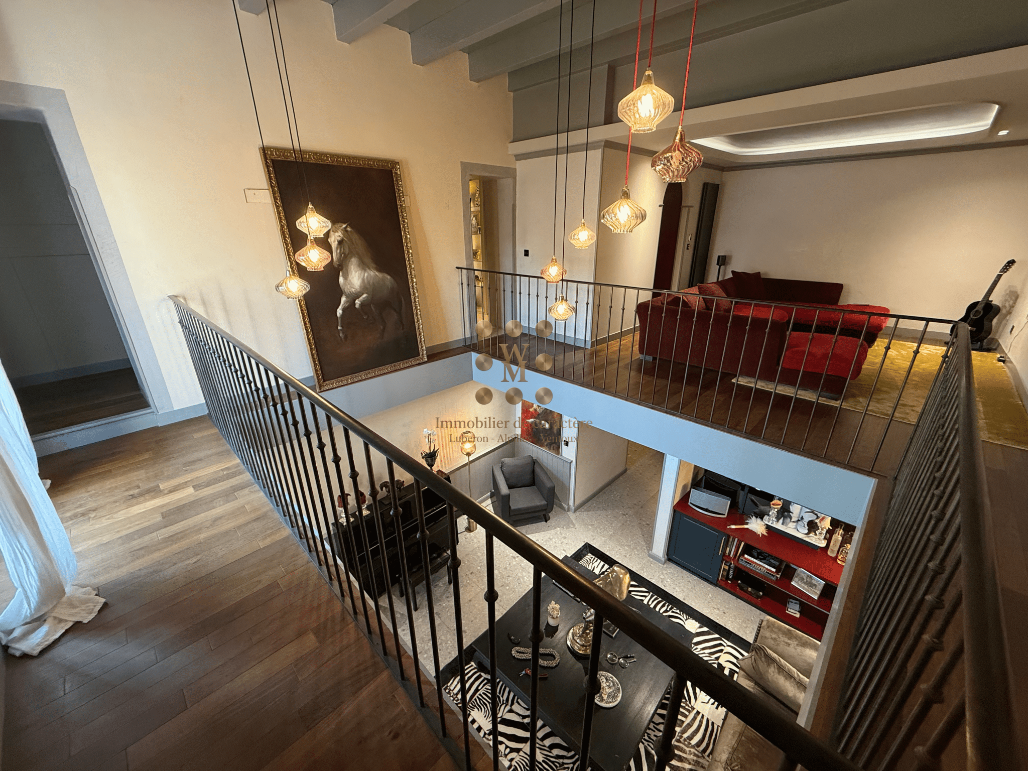 Intérieur d'une maison de maître avec un escalier en pierre et un salon moderne.