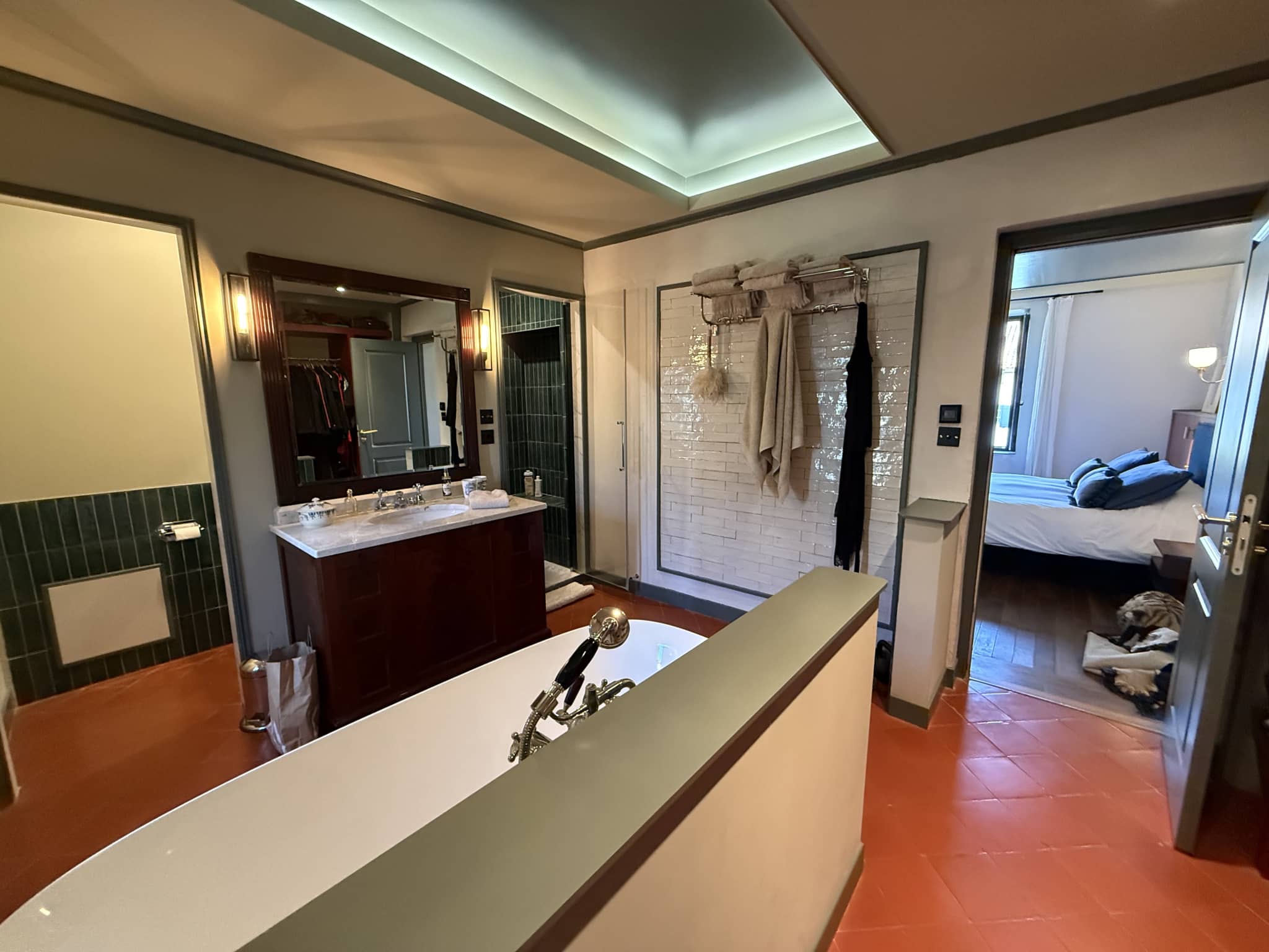 Salle de bain moderne avec baignoire, lavabo et douche, décorée avec des matériaux contemporains.