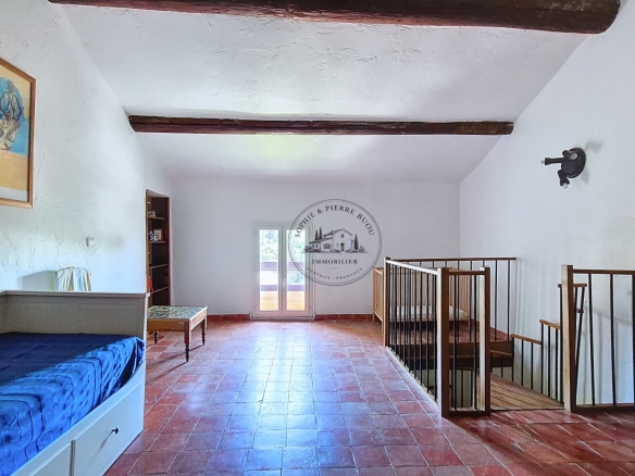 Interior of an 18th century building with exposed beams and a wooden staircase.