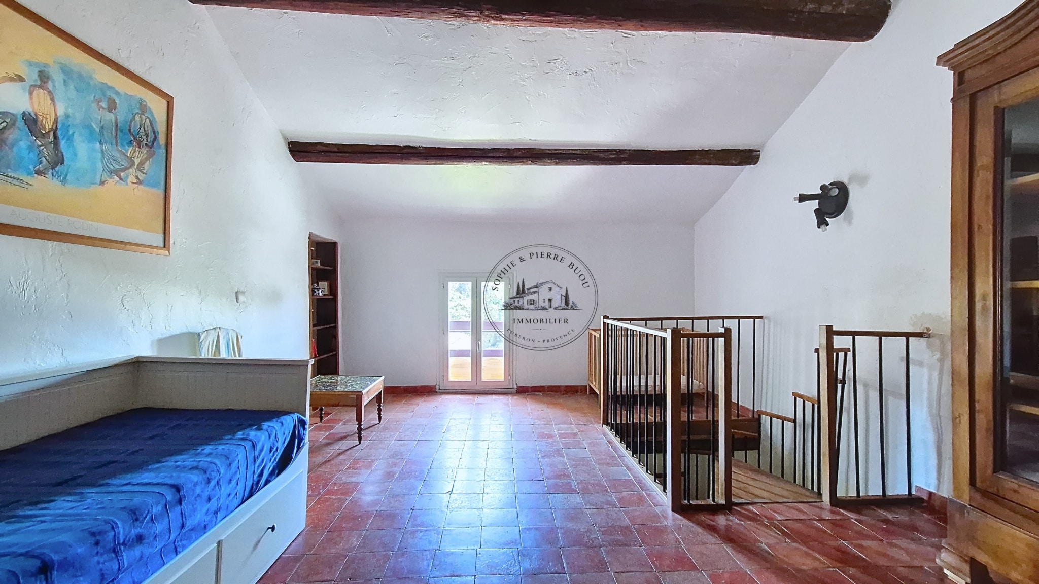 Interior of an 18th century building with exposed beams and a wooden staircase.