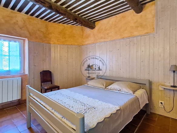Room in an 18th-century building with wooden walls and a double bed.
