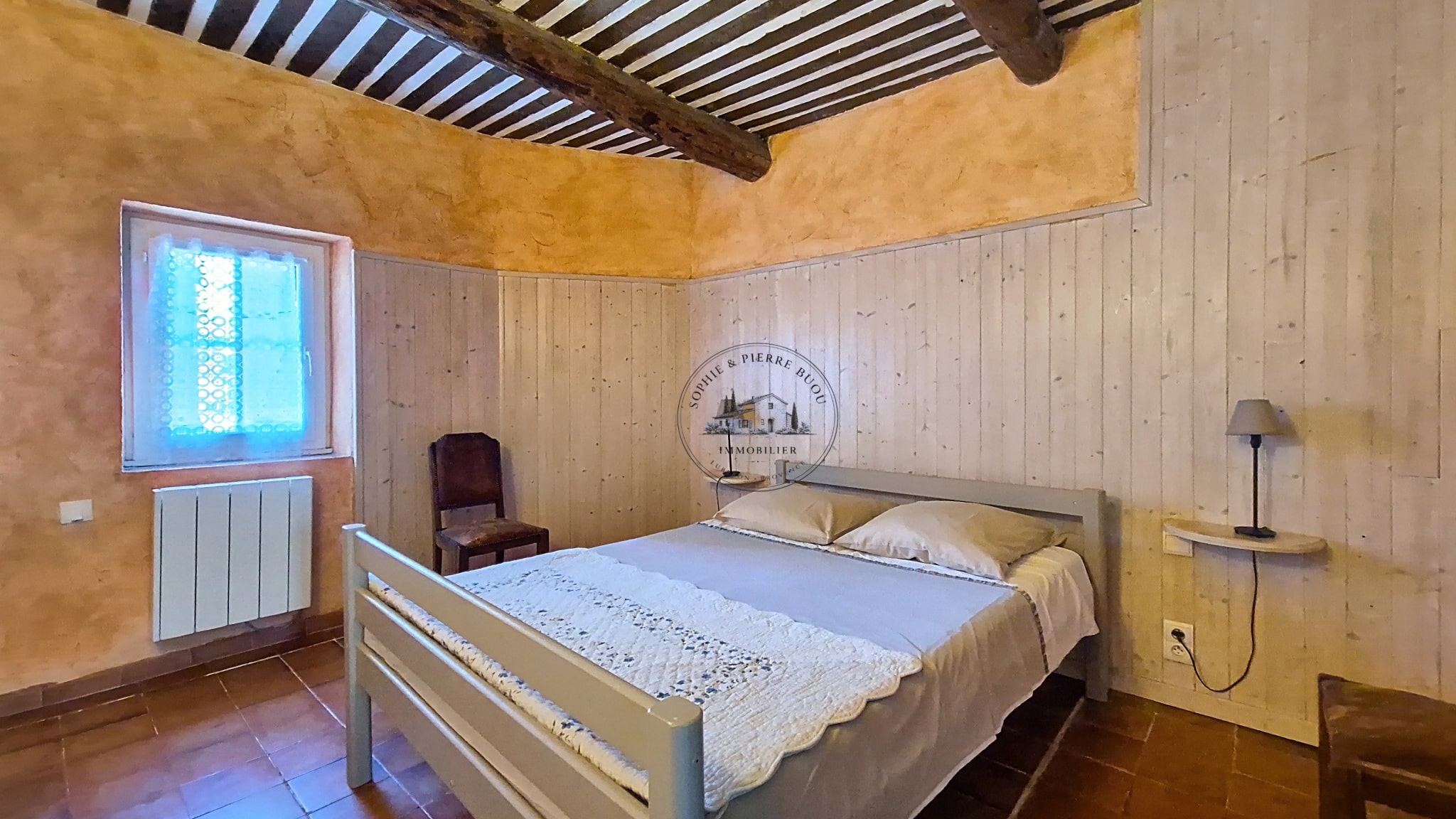 Room in an 18th-century building with wooden walls and a double bed.