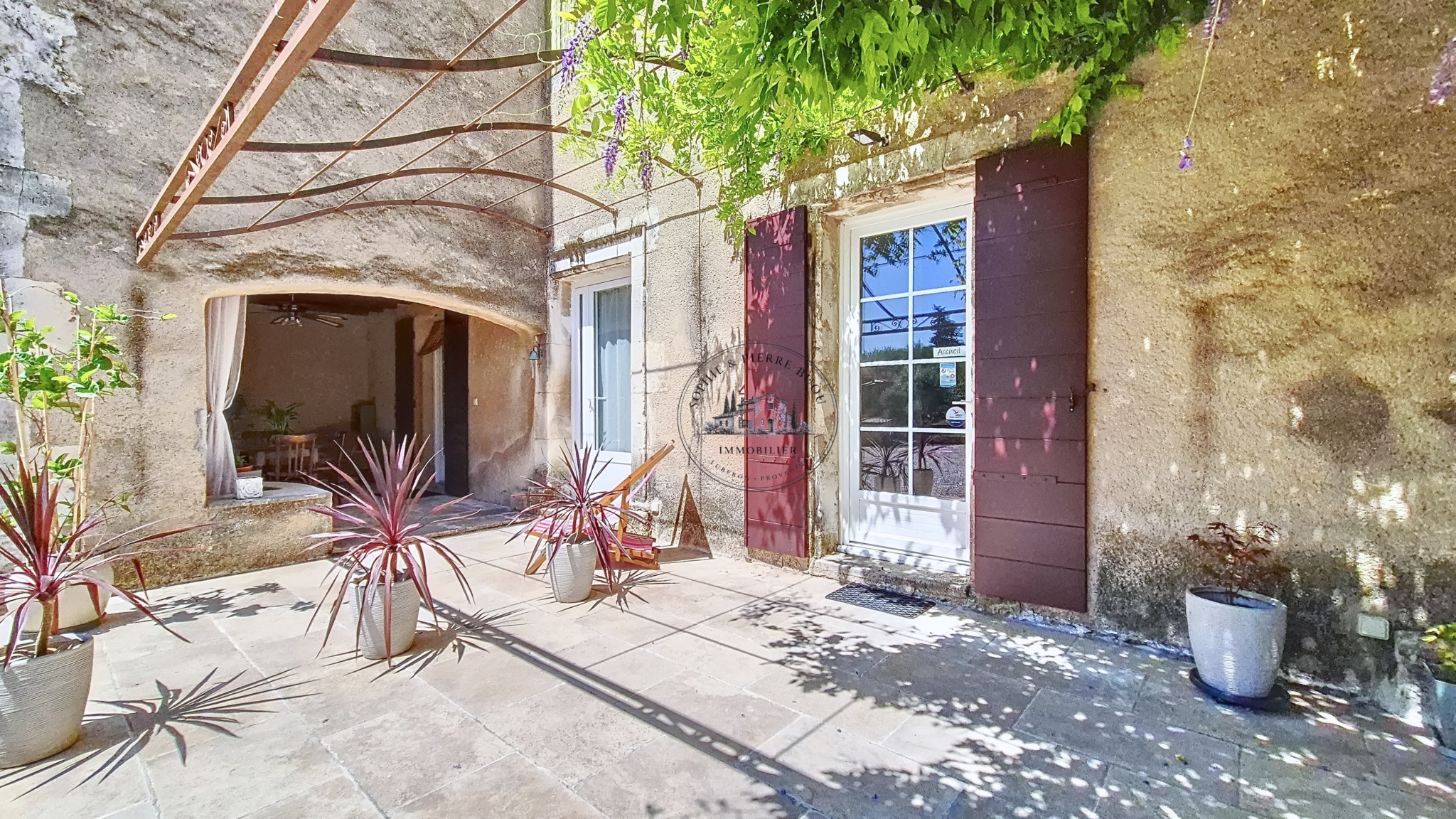 Entrance to an 18th-century building with plants and a stone terrace.