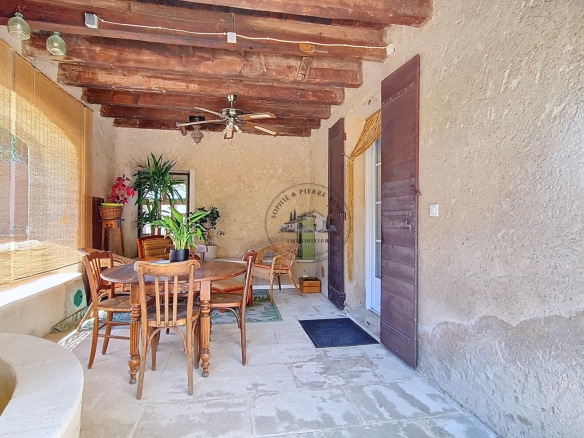 Terrace of an 18th century building with wooden furniture and plants, Cheval-Blanc.