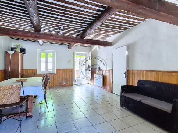 Interior of an 18th century building with exposed beams and tiled floor, Cheval-Blanc.