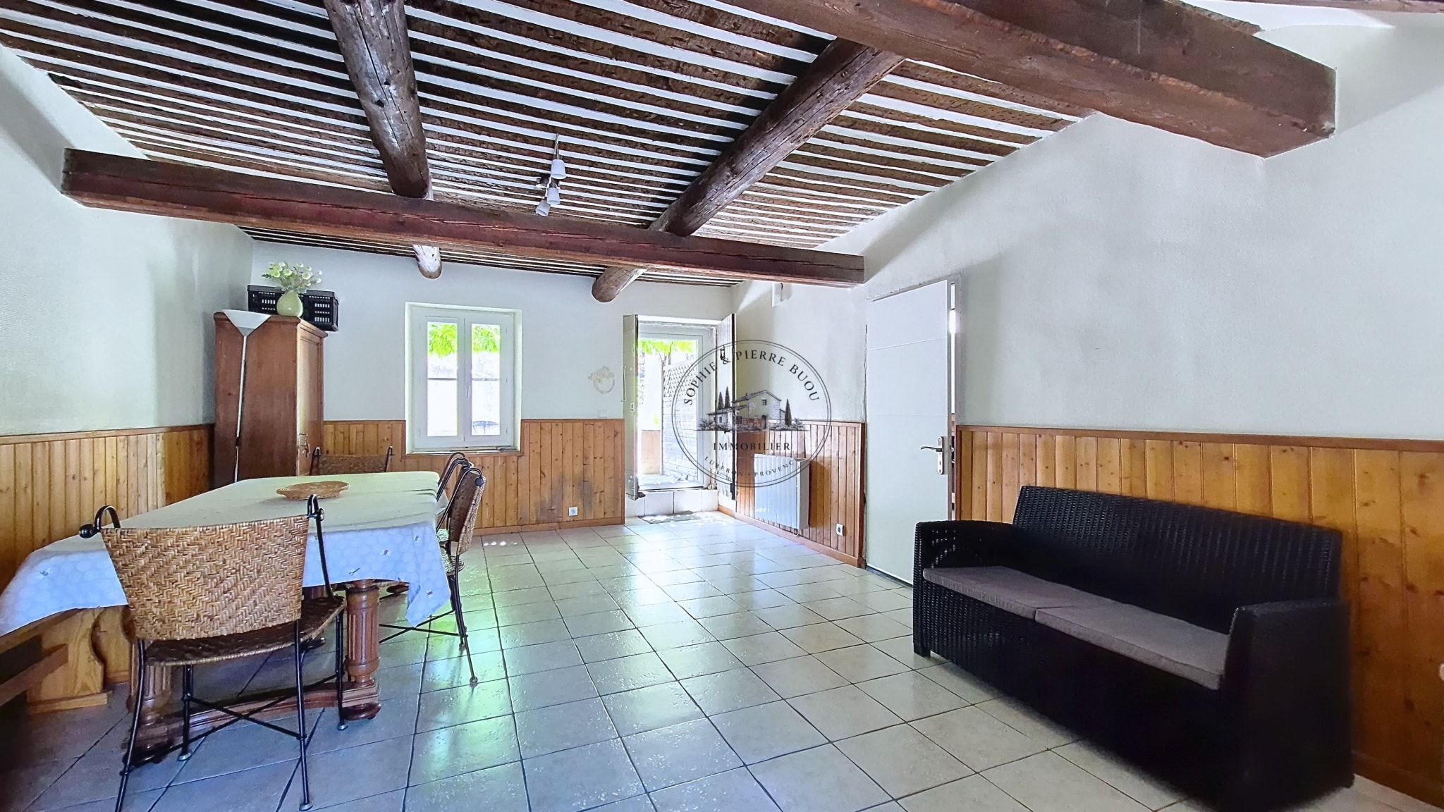 Interior of an 18th century building with exposed beams and tiled floor, Cheval-Blanc.