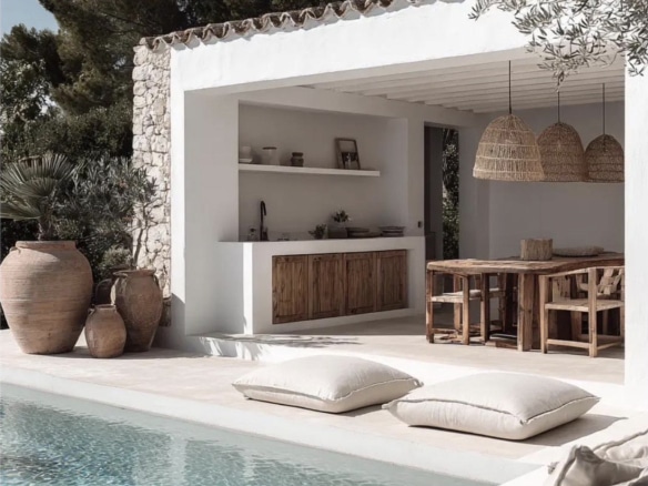 Terrasse avec piscine, mobilier en bois et décoration naturelle, entourée de verdure.