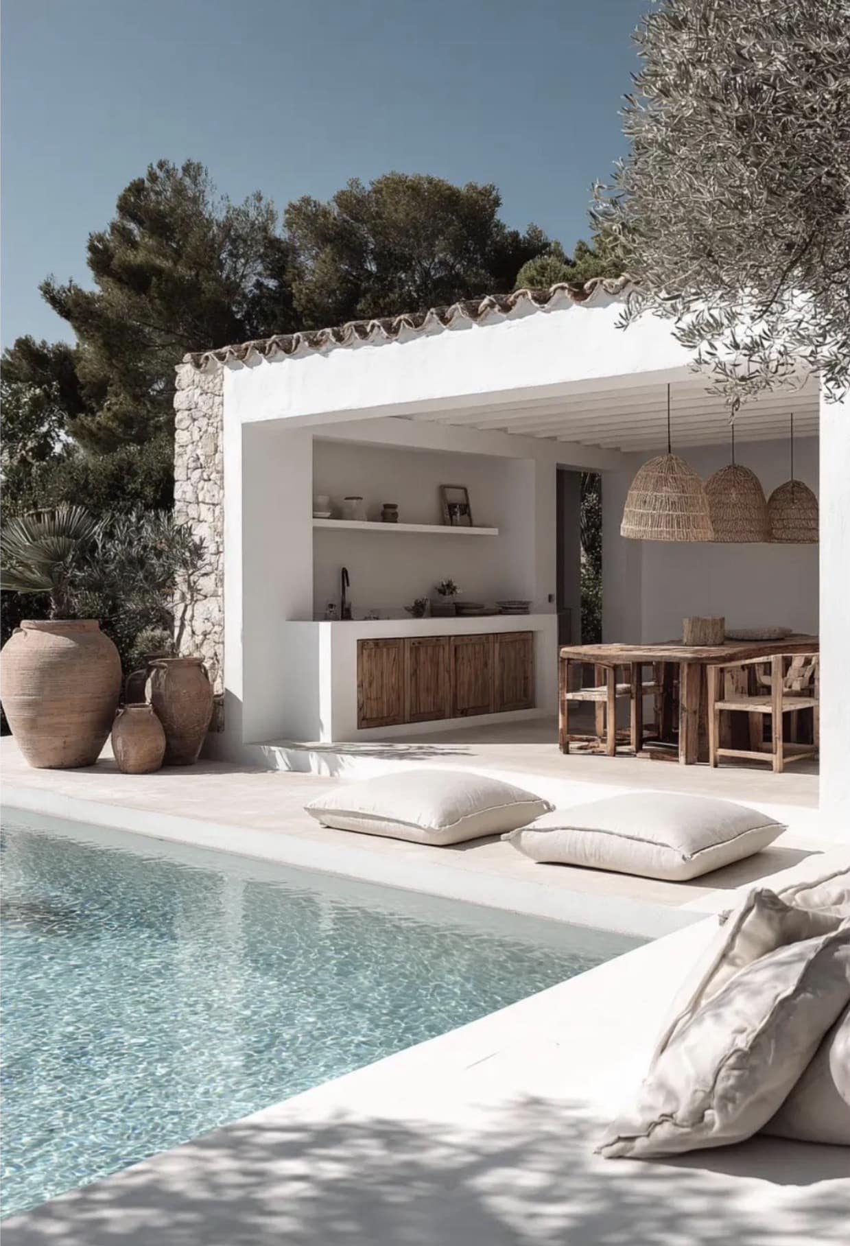 Terrasse de maison avec piscine Terrasse avec piscine, mobilier en bois et décoration naturelle, entourée de verdure.