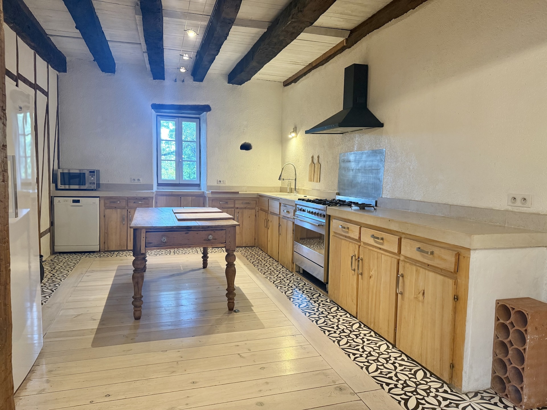 Spacious kitchen with wooden elements and decorative tiles, natural light