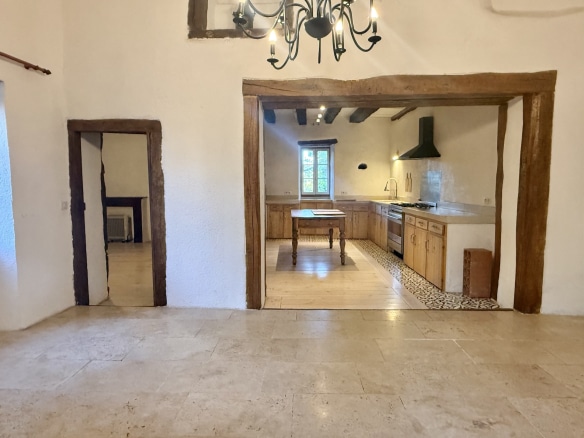 Interior of a stone house with open kitchen and wooden elements, in Touffailles.