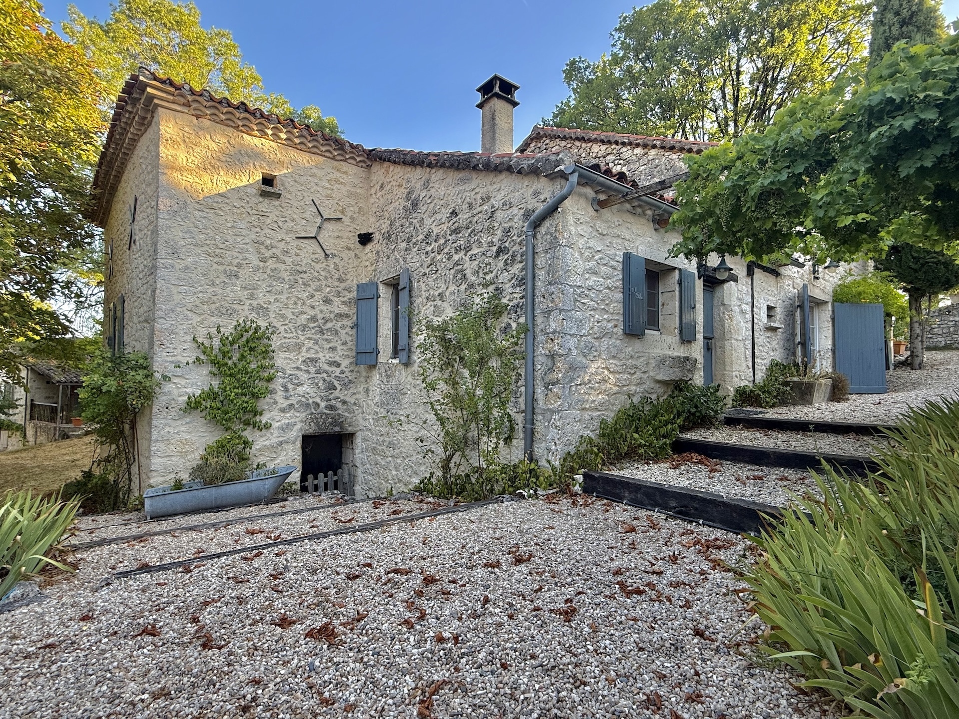 View of a stone complex with swimming pool, gardens and walkways in Touffailles.