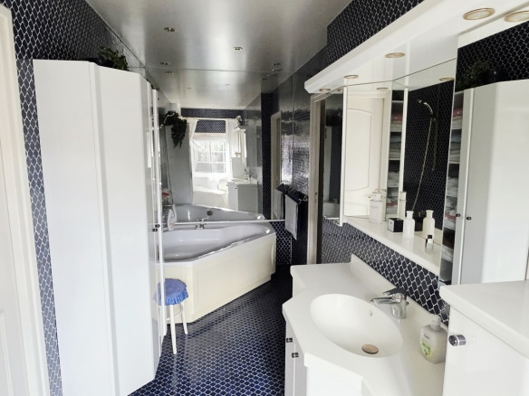 Modern bathroom with bathtub and double vanity, blue and white tiles