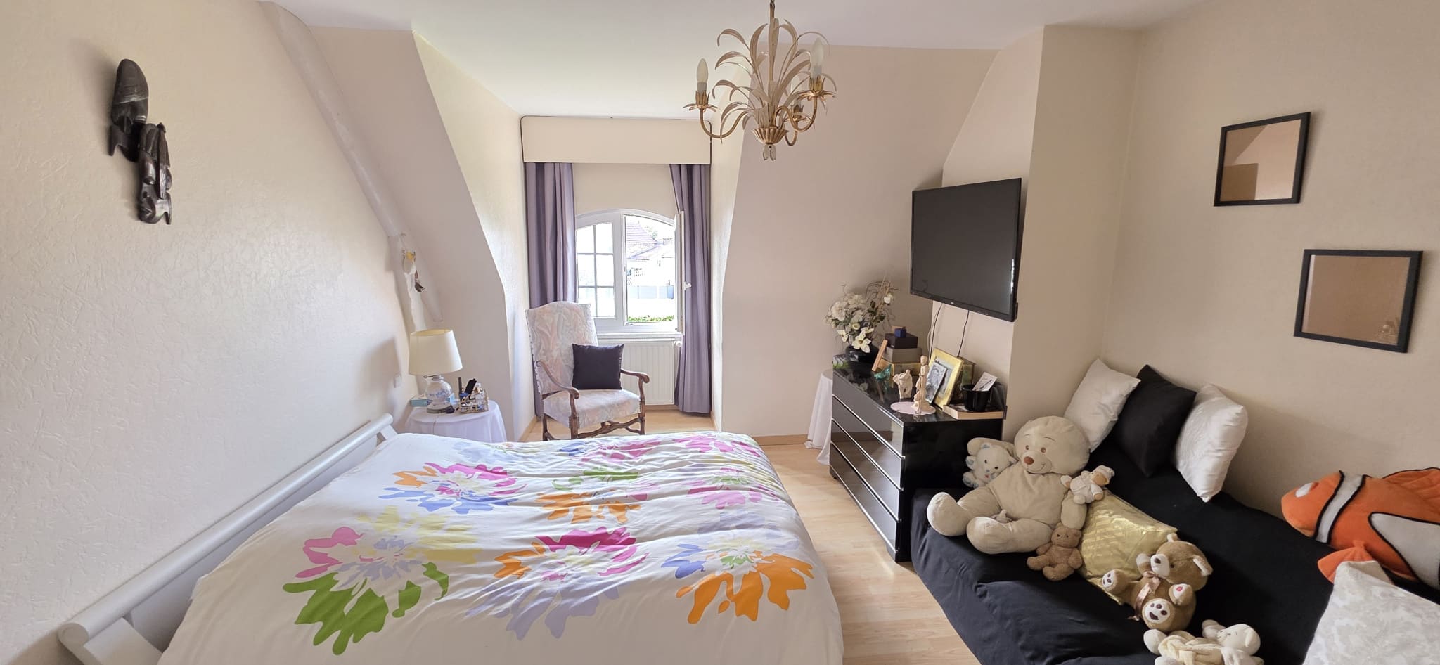 Room in a house in Bauvin Bedroom in a townhouse in Bauvin, with bed and sofa, decorated with stuffed animals.