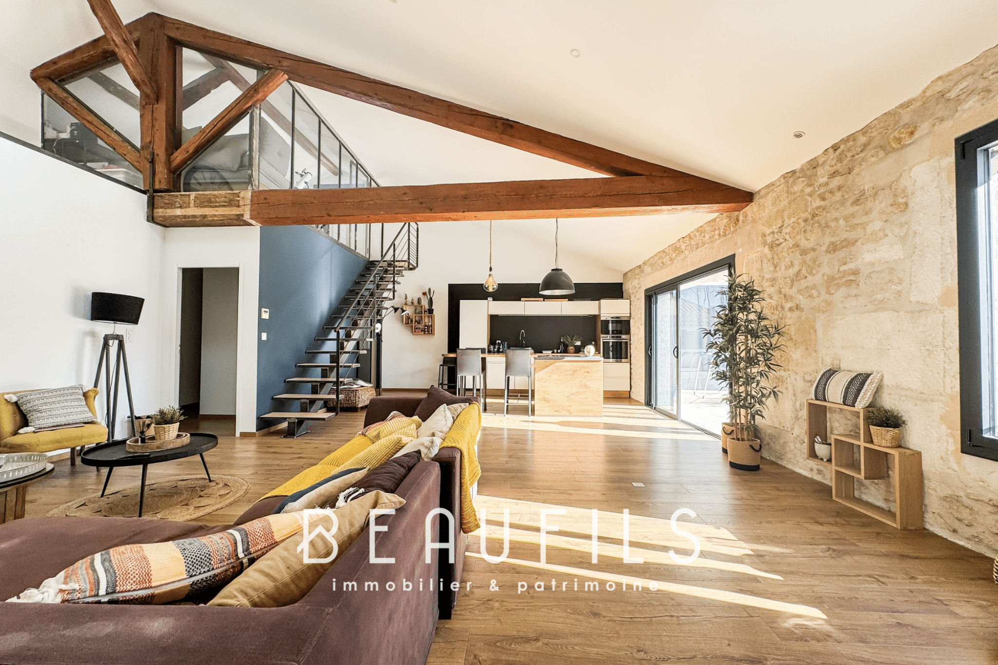 Spacious 191m2 loft with open living room and kitchen, stone walls, and exposed beams.