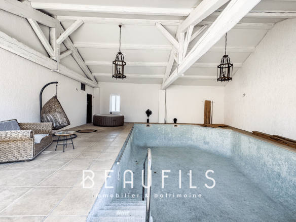 Interior of a loft with a swimming pool to be renovated, white walls and exposed beams.