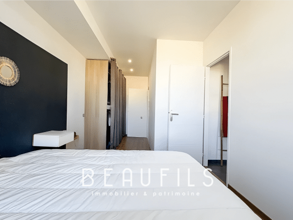 Bedroom in an unusual loft in Mauguio with a black wall and a white bed.