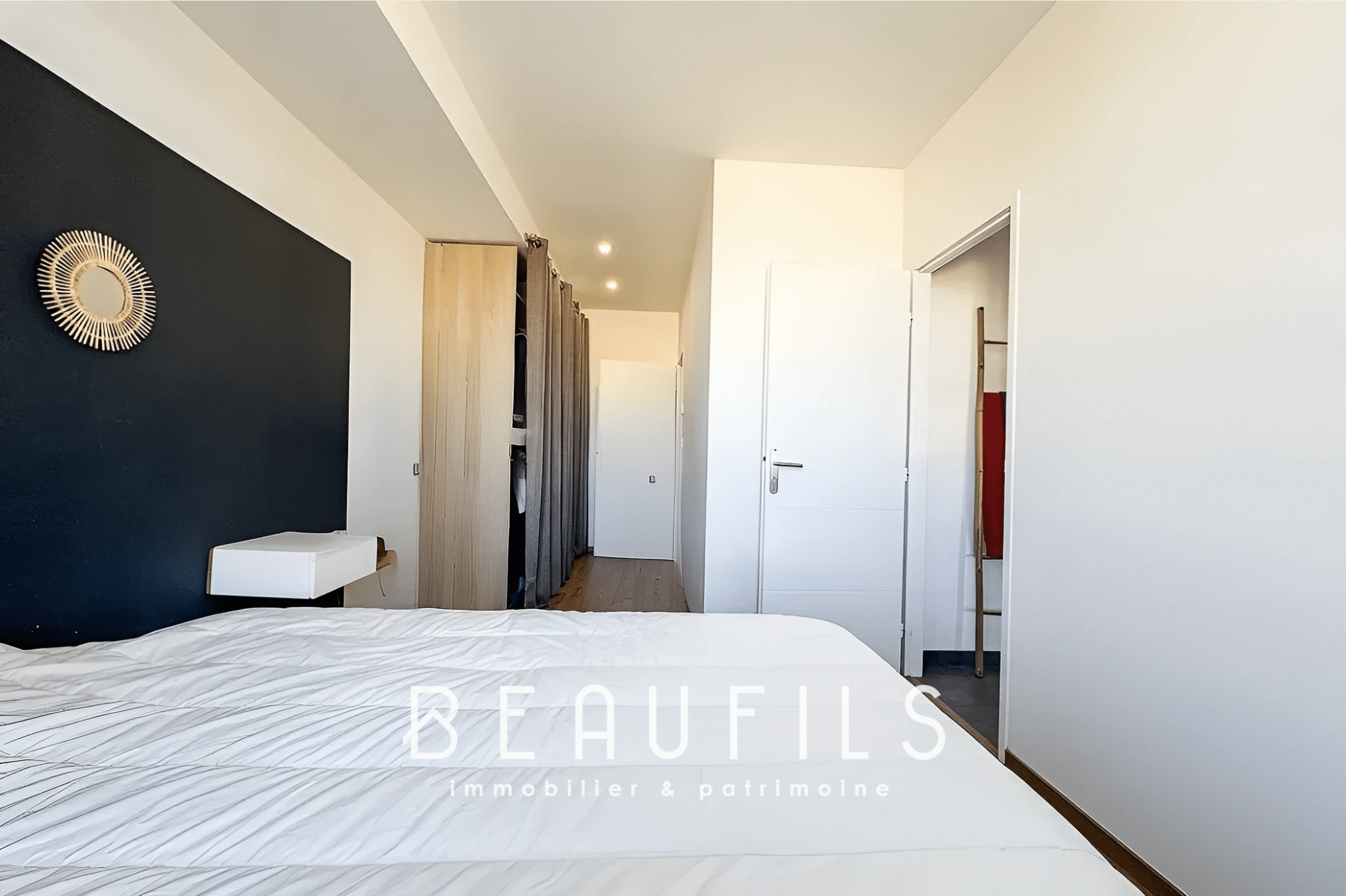 Bedroom in an unusual loft in Mauguio with a black wall and a white bed.