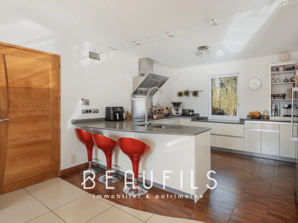 Modern kitchen with bar and red chairs in an architect-designed villa in Nîmes.