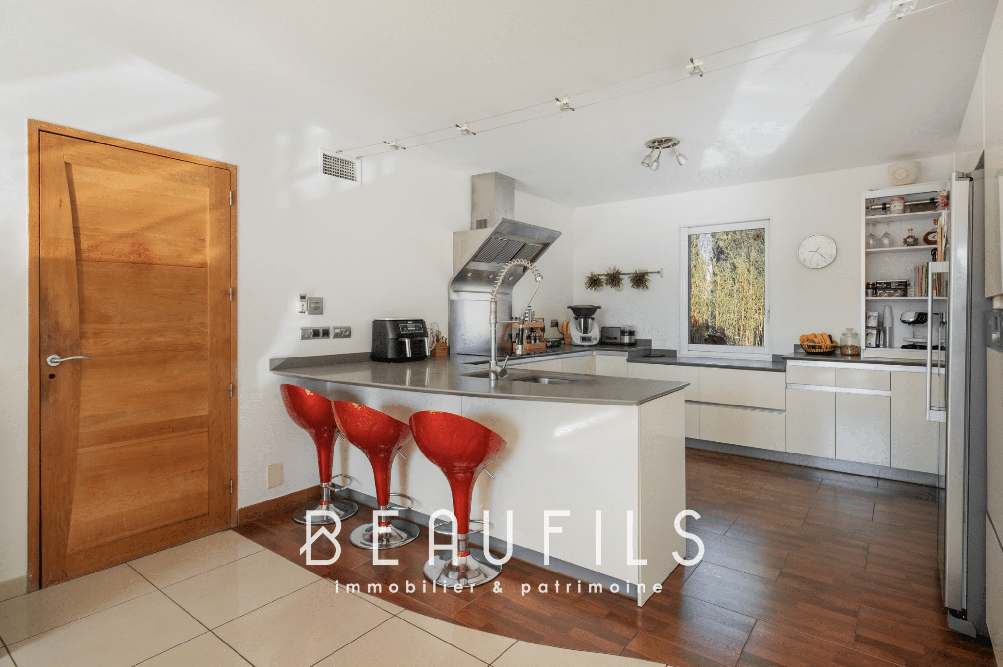 Modern kitchen with bar and red chairs in an architect-designed villa in Nîmes.