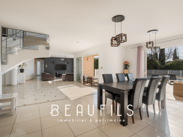 Interior of a modern architect-designed villa with a dining room and living room opening onto the outside.