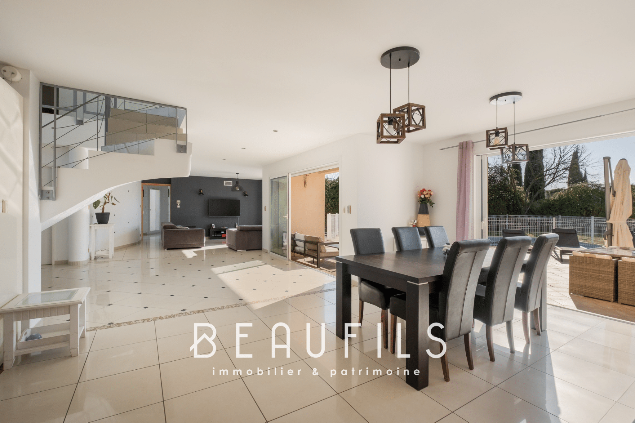 Interior of a modern architect-designed villa with a dining room and living room opening onto the outside.