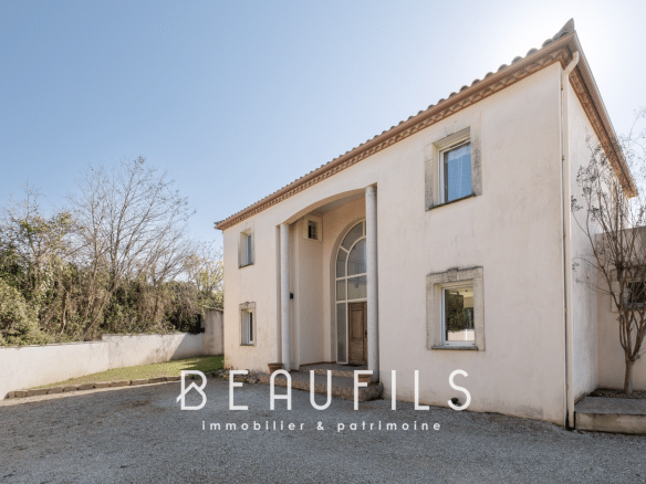 Architect-designed villa in Nîmes, façade with cathedral entrance and landscaped garden.