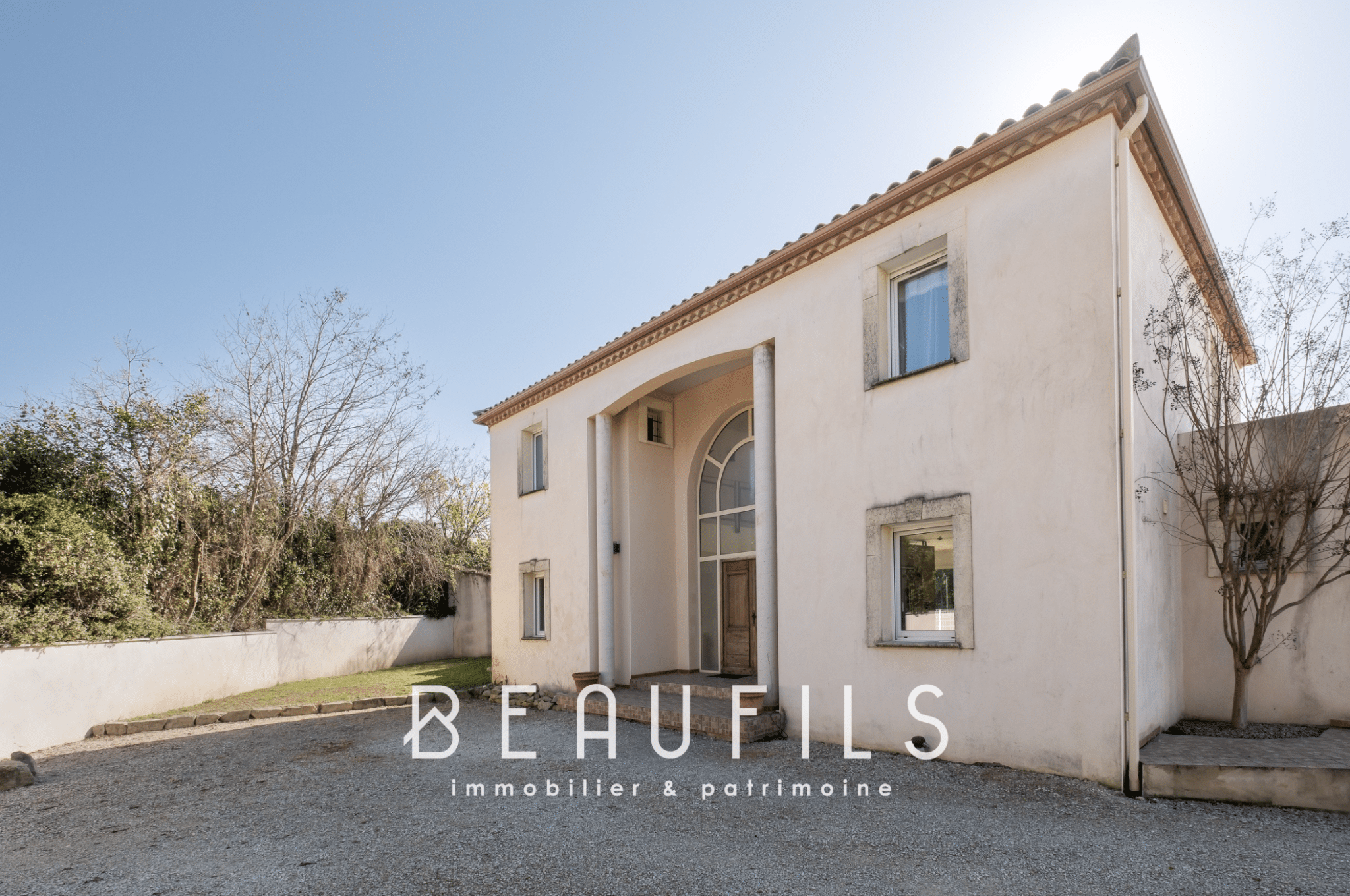 Architect-designed villa in Nîmes, façade with cathedral entrance and landscaped garden.